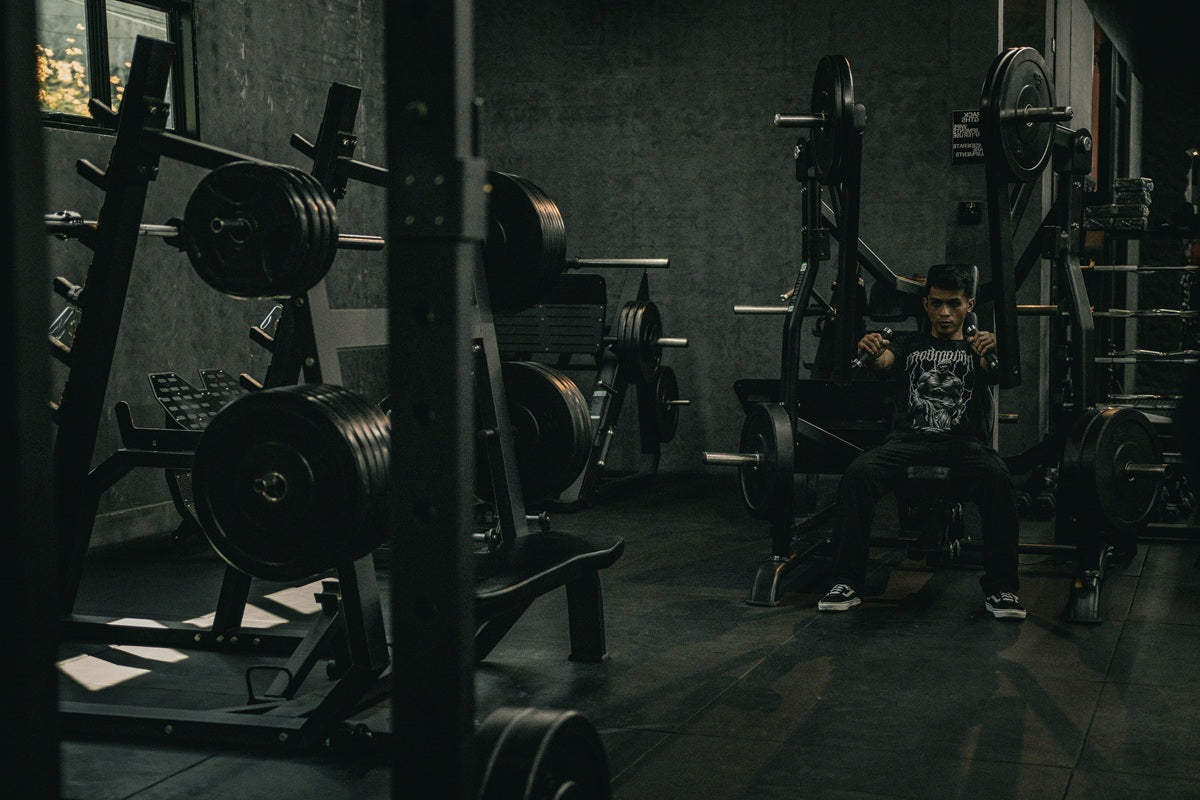 Man in a gym beside a row of treadmills, symbolising the origin of Before I Go Apparel